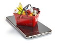 Smartphone and shopping basket with food and drink. Online groc Royalty Free Stock Photo