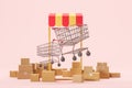 Smartphone with shopping trolleys and boxes. Online shopping app