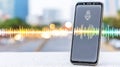 Smartphone showing a microphone icon and sound waves for artificial intelligence voice assistant technology connecting with data Royalty Free Stock Photo