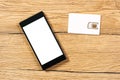 Smartphone and SIM card on office table, top view Royalty Free Stock Photo