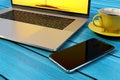 Smartphone similar to iPhone X, laptop computer, coffee Royalty Free Stock Photo