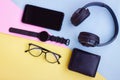 Smartphone,Smartwatch,Black Headphone,Black Wallet and Eyeglasses on pink,blue and yellow background Royalty Free Stock Photo