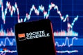Smartphone with Societe Generale bank logo. Societe Generale stock chart on the background Royalty Free Stock Photo