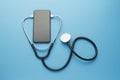 Smartphone and stethoscope on a blue background. Online medicine telemedicine technology. Service for remote diagnostic, chat