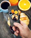 Smartphone taking food photo of breakfast