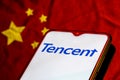 Smartphone with the Tencent logo on the background of the Chinese flag