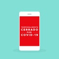 Smartphone with the text: Temporarily closed due to Covid-19 in Spanish. Temporalmente cerrado por Covid-19. Coronavirus crisis. V