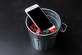 Smartphone thrown in the wastebasket. The concept of digital detox or replacing an outdated gadget. AI generated