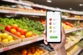 Smartphone used in grocery store displaying purchased items and prices