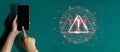 Smartphone User Engaged with Digital Security Alert Highlighted by Warning Icon and Binary Code Background Depicting Royalty Free Stock Photo