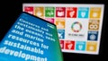 Smartphone with web page of UN Sustainable Development Goals (SDG) on screen in front of logo.