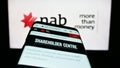 Smartphone with webpage of company National Australia Bank Limited (NAB) on screen in front of business logo.