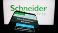 Smartphone with webpage of French company Schneider Electric SE on screen in front of business logo. Royalty Free Stock Photo