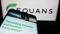 Smartphone with webpage of French facility management company EQUANS on screen in front of business logo.