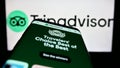 Smartphone with webpage of US travel company Tripadvisor Inc. on screen in front of business logo.