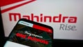 Smartphone with website of Indian automotive company Mahindra Mahindra Limited on screen in front of logo.