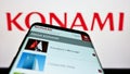 Smartphone with website of Japanese company Konami Group Corporation on screen in front of business logo.