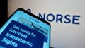 Smartphone with website of Norwegian airline Norse Atlantic Airways on screen in front of business logo.