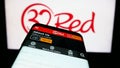 Smartphone with website of online casino company 32Red Limited on screen in front of business logo.