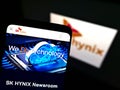Smartphone with website of South Korean semiconductor manufacturer SK hynix Inc. on screen in front of logo.