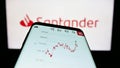 Smartphone with website of Spanish banking company Banco Santander S.A. on screen in front of business logo. Royalty Free Stock Photo