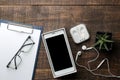 Smartphone white and a cup with coffee glasses and a blank on a brown wooden table. view from above Royalty Free Stock Photo