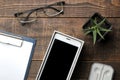 Smartphone white and a cup with coffee glasses and a blank on a brown wooden table. view from above Royalty Free Stock Photo