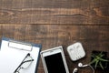 Smartphone white and a cup with coffee glasses and a blank on a brown wooden table. view from above Royalty Free Stock Photo