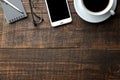 Smartphone white and a cup with coffee glasses and a notepad on a brown wooden table. view from above Royalty Free Stock Photo