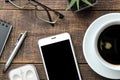 Smartphone white and a cup with coffee glasses and a notepad on a brown wooden table. view from above Royalty Free Stock Photo