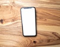 Smartphone with White Screen on Wooden Table in Top View with Natural Light Royalty Free Stock Photo