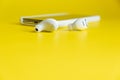 Smartphone white wireless headphones on a bright yellow background