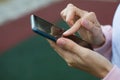 Smartphone in women`s hands close-up. Using the phone, fingers on the touch screen of the gadget. Text messages, doing business, I Royalty Free Stock Photo