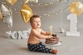 Smash cake party. Little cheerful birthday boy with first cake. Happy infant baby celebrating his first birthday. Decoration and Royalty Free Stock Photo