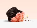 Dropped cupcake with candle flame on a pink Royalty Free Stock Photo