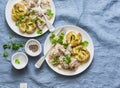 Smashed roasted sage butter potatoes and mustard cream sauce meat - tasty lunch on blue background