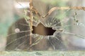 Smashed window pane with a hole in the middle Royalty Free Stock Photo