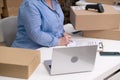 SME businesswoman packing orders for delivery working laptop.preparing package for express shipping