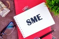 The SME symbol in a notebook on a blank sheet in a Royalty Free Stock Photo