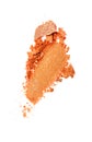 Smear of crushed shiny orange eyeshadow as sample of cosmetic product Royalty Free Stock Photo