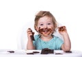 Smeared baby eating chocolate  on an  background Royalty Free Stock Photo