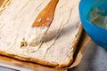 Smearing a baked roll cake with whipped butter cream Royalty Free Stock Photo