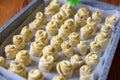 Smearing the dough with egg yolk with silicone brush. Baking in the shape of a rose or snail. Baking snail. Close-up