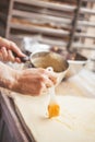 Smearing raw dough with brush in yolk