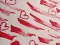 Smears of red lipstick and hearts on white background