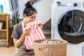 Smell, smile young asian woman doing fresh laundry from the washing machine in home. Happy girl and a home cleaner smelling a Royalty Free Stock Photo