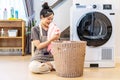 Smell, smile young asian woman doing fresh laundry from the washing machine in home. Happy girl and a home cleaner smelling a Royalty Free Stock Photo