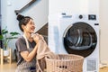 Smell, smile young asian woman doing fresh laundry from the washing machine in home. Happy girl and a home cleaner smelling a Royalty Free Stock Photo