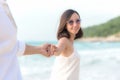 Smelling Couple summer Vacation, Asian young woman holding man hand on the beach, so happy and in love on honeymoon holiday Royalty Free Stock Photo
