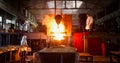 Smelting metal in a metallurgical plant. Liquid iron from metal ladle pouring in castings